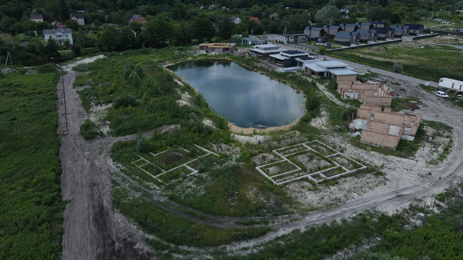 Озеро і фундаменти нових будинків — котеджне містечко OASIS, зйомка з дрона